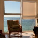 brown wooden framed padded armchair near window